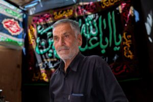 A volunteer who serves tea and syrup to the participants during the Ashura & Tasua ritual ceremony